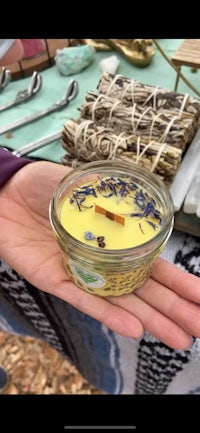 a person is holding a candle in a jar