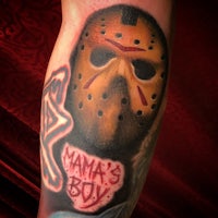a tattoo of a mask with the words mama's boy