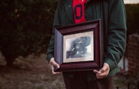 a man holding up a framed photo