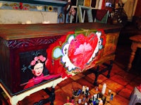 a painting of frida kahlo on a chest of drawers