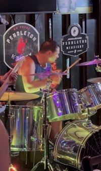 a group of men playing drums in a bar