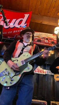 a man is playing a guitar in a bar