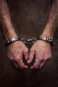 a man's hands are in handcuffs on a dark background