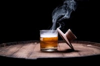a glass of whiskey with smoke coming out of it