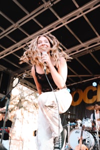 a woman singing on stage at a music festival