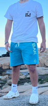 a man wearing a white t - shirt and blue shorts