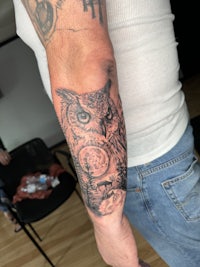 a tattoo of an owl on a man's arm