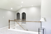 a stairway in a home with white walls and a light fixture