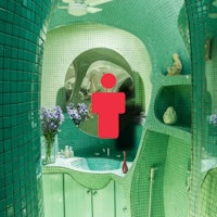 a bathroom with green tiles and a mirror