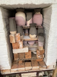 a brick oven with a lot of pots in it