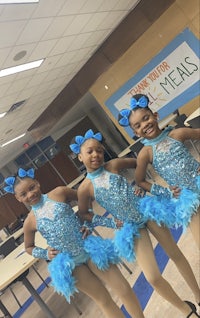 three girls in blue dance outfits posing for a picture