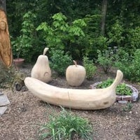 a wooden sculpture of a banana in a garden