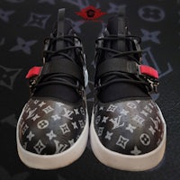 a pair of louis vuitton sneakers on a black background