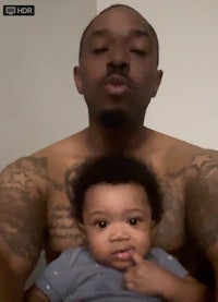 a man with tattoos holding a baby