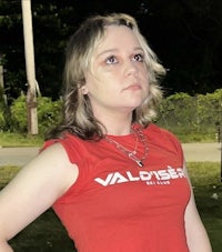 a woman in a red t - shirt is posing for a picture