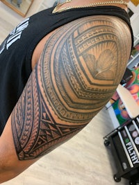 a man with a tribal tattoo on his sleeve