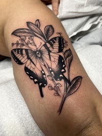 a black and white butterfly tattoo on a woman's arm