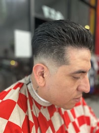 a man is getting a haircut at a barber shop