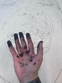 a person's hand with black paint on it