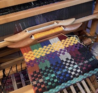 a loom with a colorful weaving on it