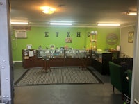 a marijuana store with a green wall and chairs