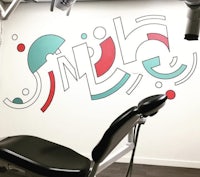 a dental office with a chair in front of a colorful wall