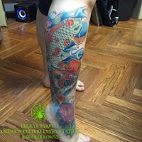 a koi fish tattoo on the leg of a woman