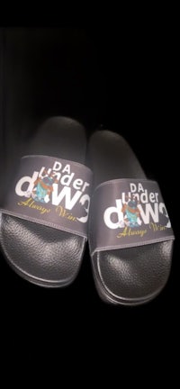 a pair of black slide sandals with a logo on them