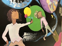 a mural depicting a group of people playing with balloons