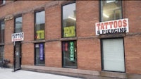 a building with signs for tattoos and piercings
