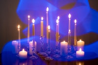 a group of candles on a table in front of a blue light