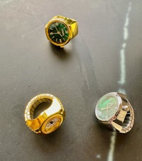 a group of watches and rings on a table