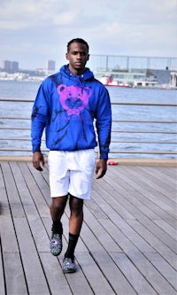 a black man wearing a blue hoodie and shorts