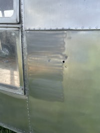 a close up of a silver airstream with holes in it
