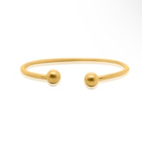a gold plated cuff bracelet with two gold balls