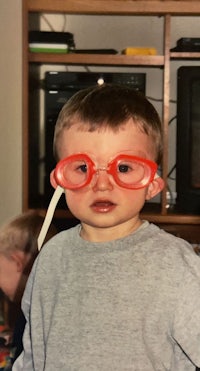 a young boy wearing a pair of glasses