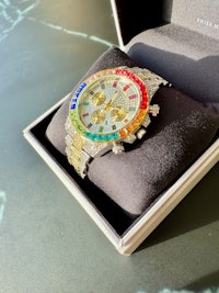 a watch in a box with a rainbow dial