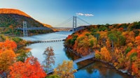 a bridge over a river surrounded by fall foliage