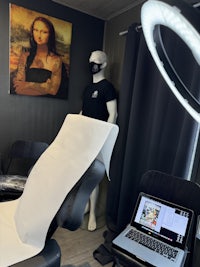 a tattoo studio with a mannequin and a laptop