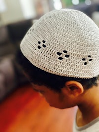 a young boy wearing a crocheted kippah