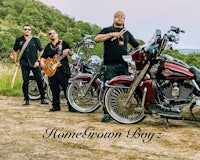 a group of men standing next to motorcycles on a dirt road
