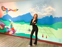 a woman standing in front of a mural