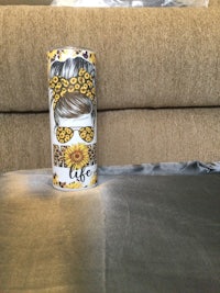 a can with a picture of a sunflower sitting on top of a couch
