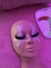 a mannequin with fake eyelashes on a bed