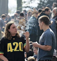 two people smoking marijuana in a crowd