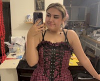 a woman in a pink and black corset taking a selfie