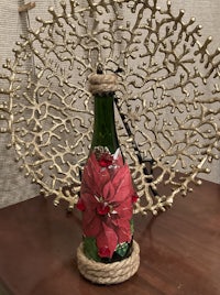 a glass bottle with a red poinsettia on it