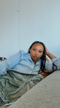 a woman with dreadlocks laying on a couch