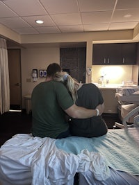 a man and woman sitting on a bed in a hospital room