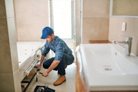 a plumber fixing a sink in a bathroom